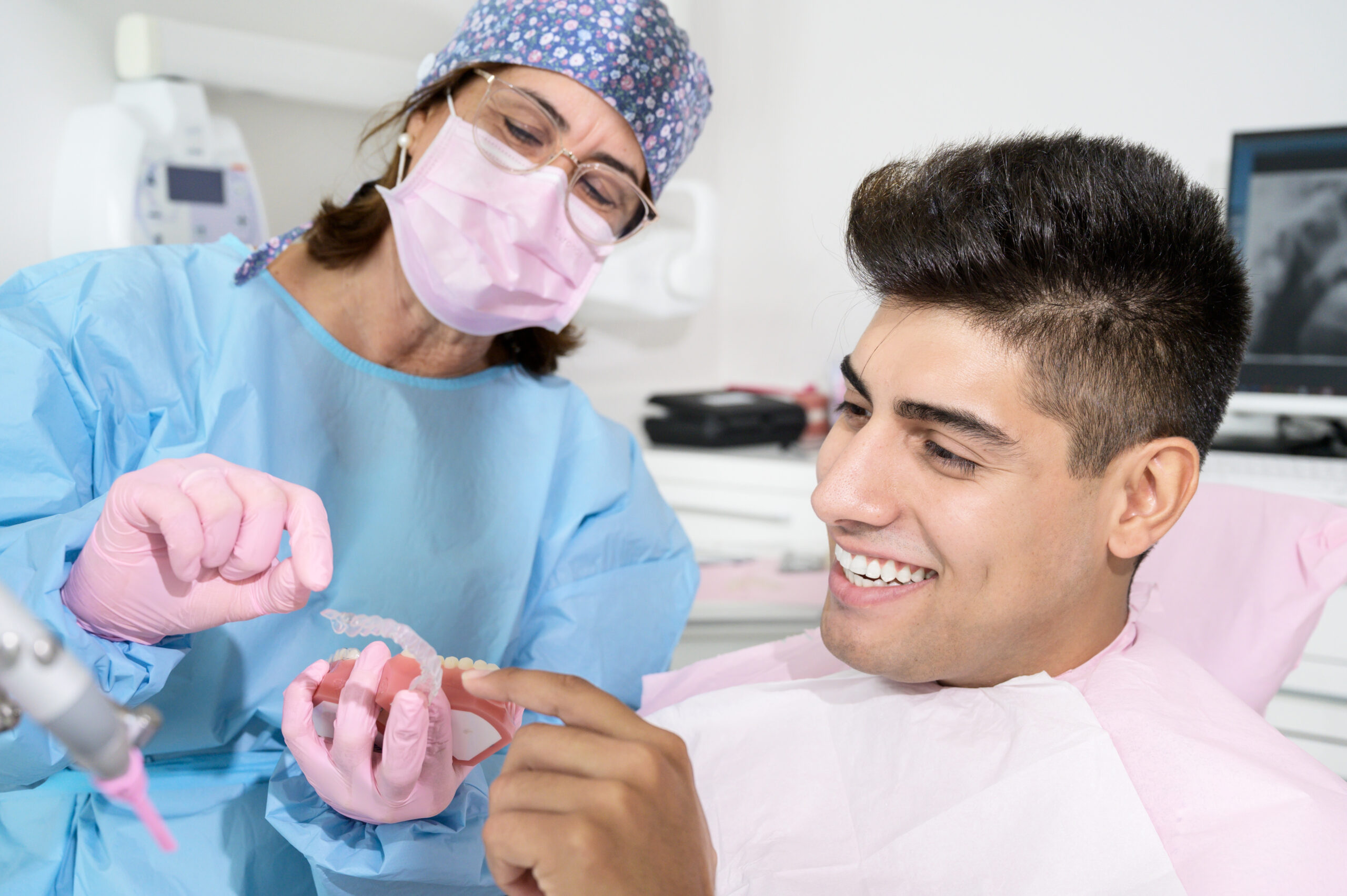 Dentist explaining removable braces for teeth to a smiling patient, highlighting a convenient and effective orthodontic treatment option.